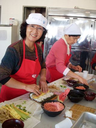 日系人のイベントで巻き寿司を作る女性