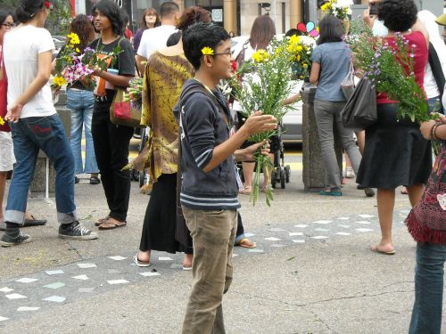 様々な民族の若者達が花を配る
