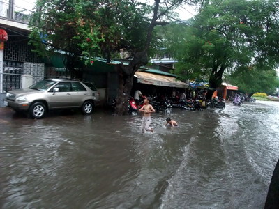 洪水の道路で遊ぶ子ども