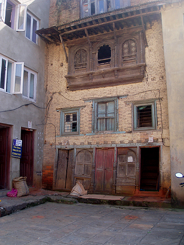 郊外の家屋。1階の木の柱が奥へ向かって傾いています。