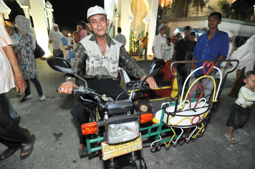 バイクタクシーの運転手として働くスレイマンさん。普段はイスラム寺院の前で客待ちをしている。