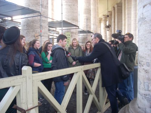 寺院入場のため列に並ぶ観光客にインタビューする報道陣