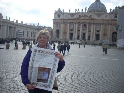バチカン市国刊行新聞の一面記事「新教皇誕生」を持つ観光客