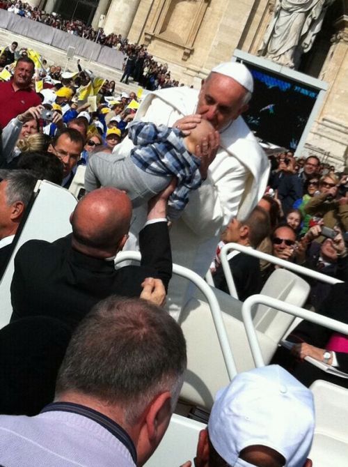 教皇移動車で広場巡回中、乳児にキスする教皇