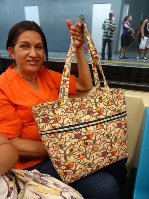 フクロウ柄プリントの手提げかばんを持つ女性