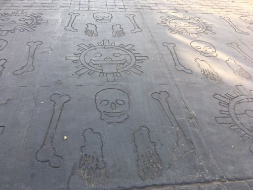 骸骨と骨、この街の象徴でもある太陽を彫り込んだ敷石