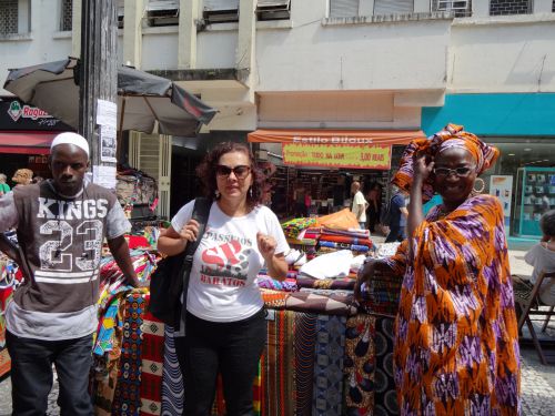アフリカ雑貨の露店が並ぶ通りで案内するパセイオバラートのコーディネーター