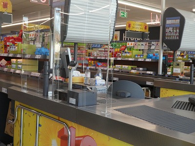 スーパーマーケットのレジは、買い物客と直に接することのないよう、透明の板で仕切られていました