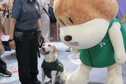 舞台の活動終了後、検疫犬「ナオミ」はブースに行き、マスコットキャラクターの「貝果（読みは『ベイグォ』で、ベーグルの意味）」